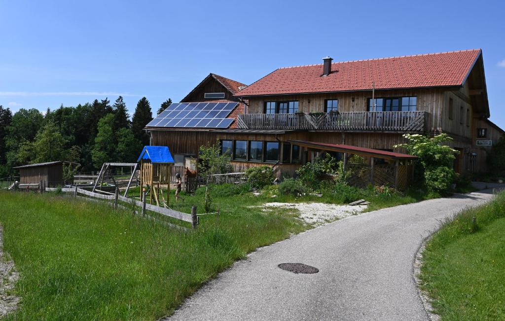 uma casa com painéis solares no lado de uma estrada em Biohof Schmidbauer em Frankenburg