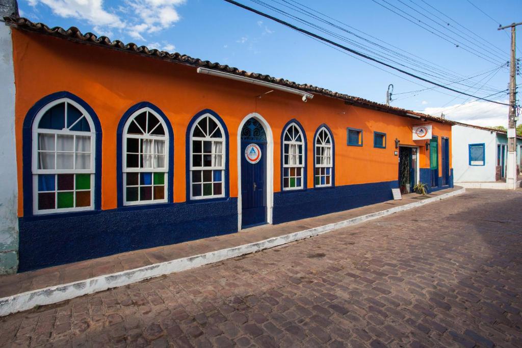 an orange and blue building on the side of a street at HI Hostel Chapada in Lençóis