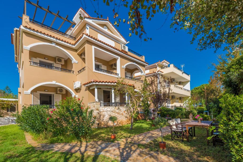 a large house with a garden in front of it at Mavra Elegant Apartments in Zakynthos