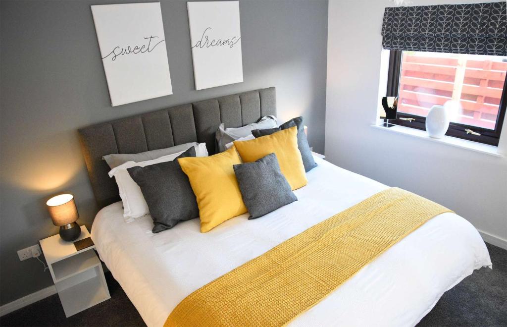 a bedroom with a bed with yellow and gray pillows at The apartment at Glendaruel in Portree