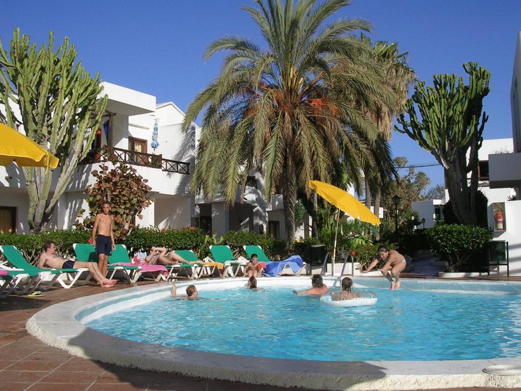 um grupo de pessoas sentadas numa piscina em Apartamentos Maribel em Puerto del Carmen