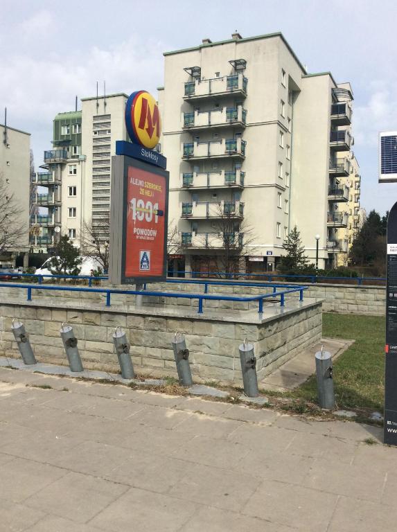 Um sinal do McDonald's em frente a um edifício. em Apartment next Metro - Adults Only em Varsóvia