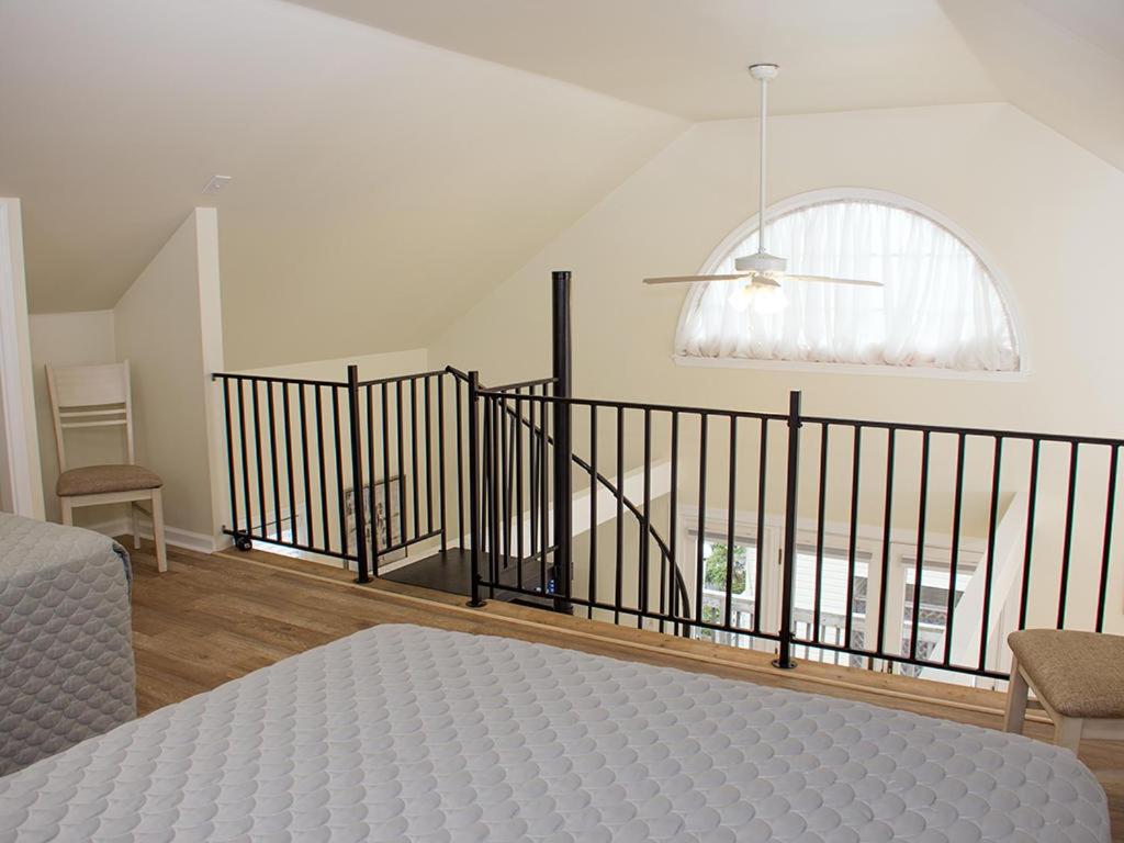 een slaapkamer met een bed en een trap met een raam bij 900 Philadelphia in Ocean City