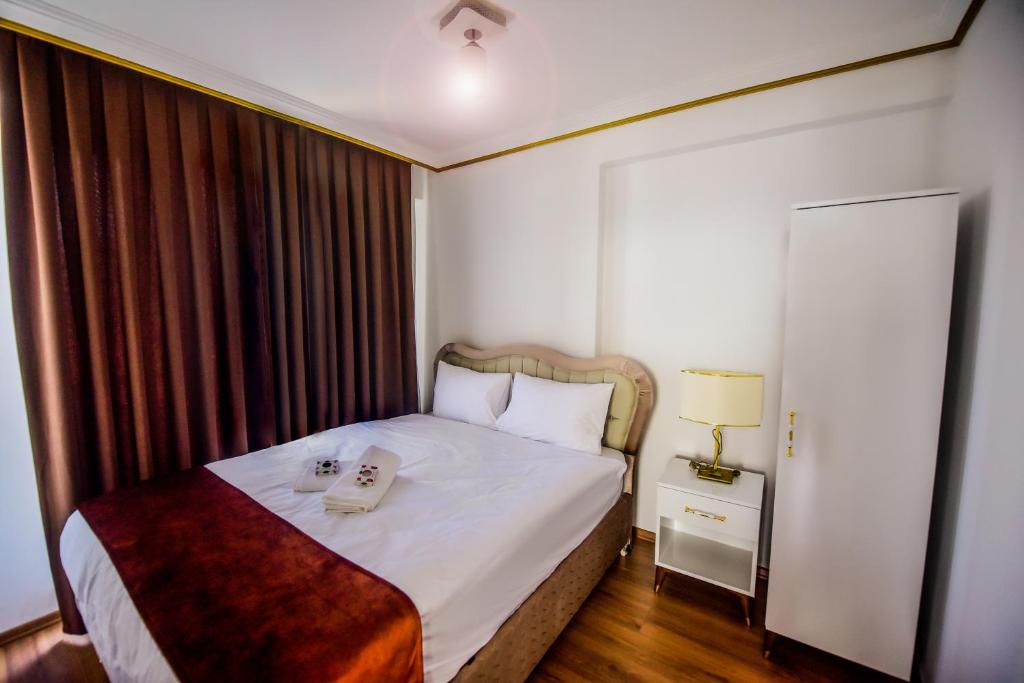 a hotel room with a bed with a phone on it at Rosa Therapy Butik Otel in Isparta