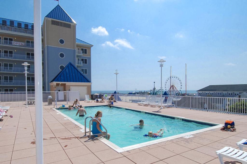 a pool with people in it with a roller coaster at Belmont Towers 410 in Ocean City