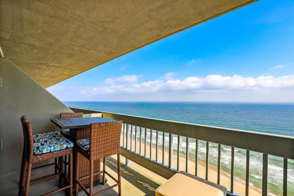 een balkon met een tafel en stoelen en de oceaan bij Century 2 in Ocean City