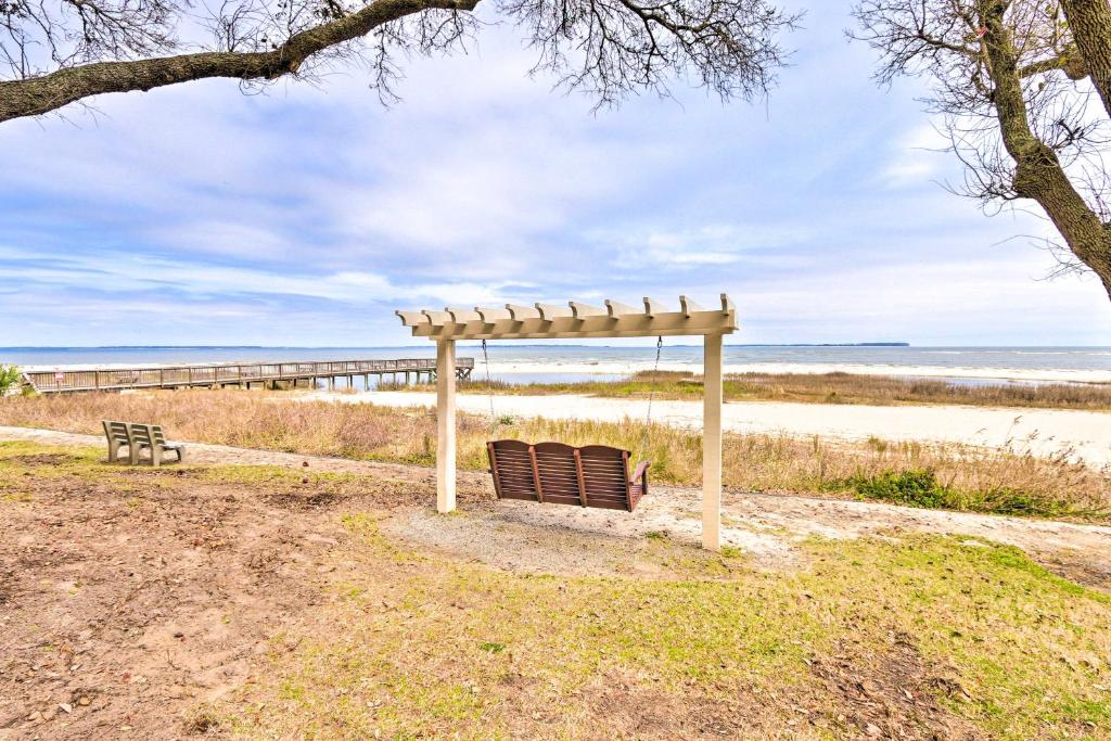 a wooden bench sitting next to the beach at Hilton Head Condo with Pool and Beach Access! in Hilton Head Island