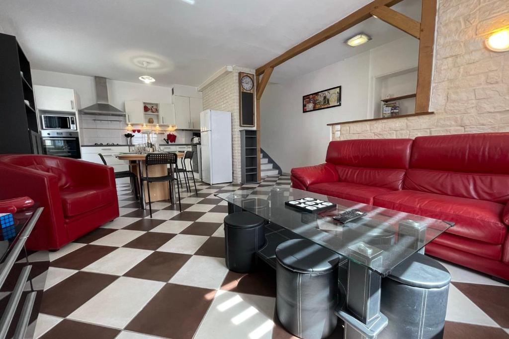 sala de estar con sofá rojo y mesa en Town house in the heart of the Cher Valley near Amboise, en Bléré