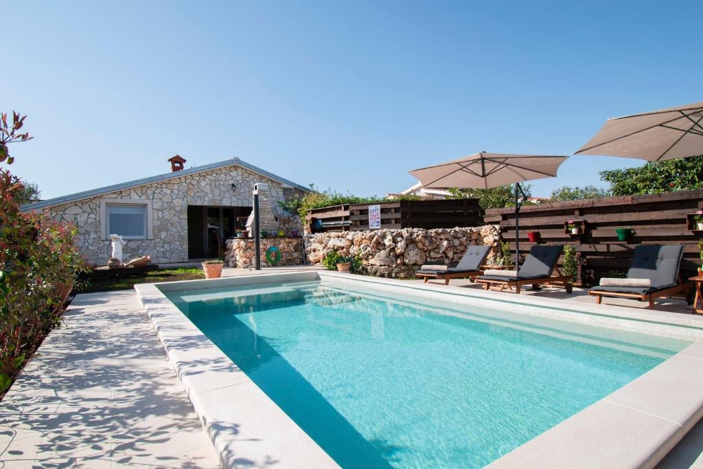 a swimming pool with two chairs and a house at Haus Vita in Pula