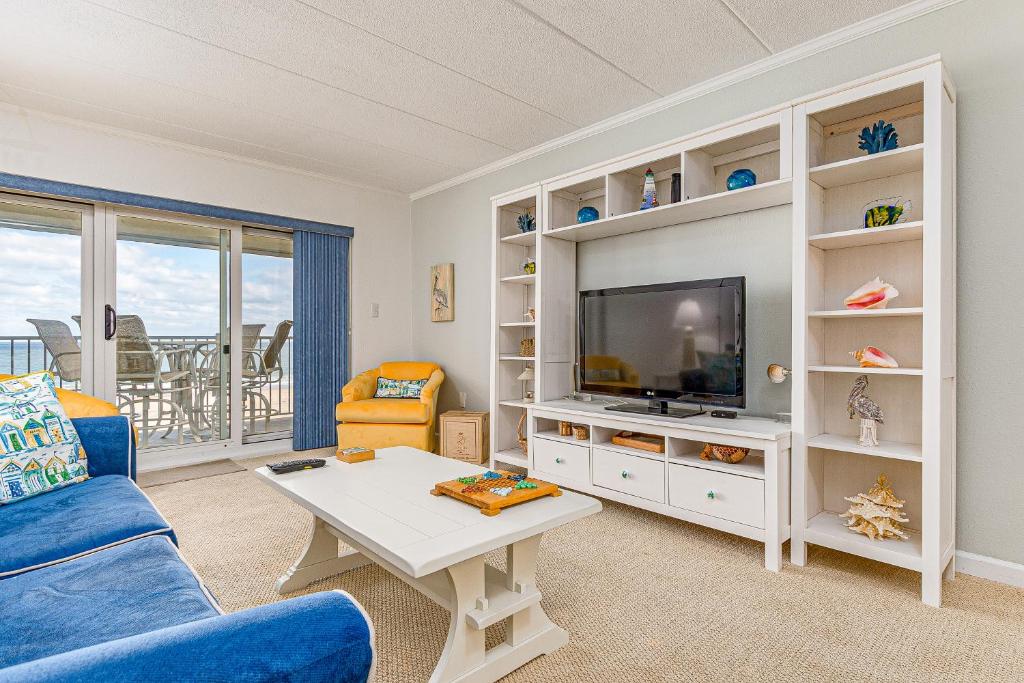 sala de estar con sofá azul y TV en Pelican Beach, en Ocean City