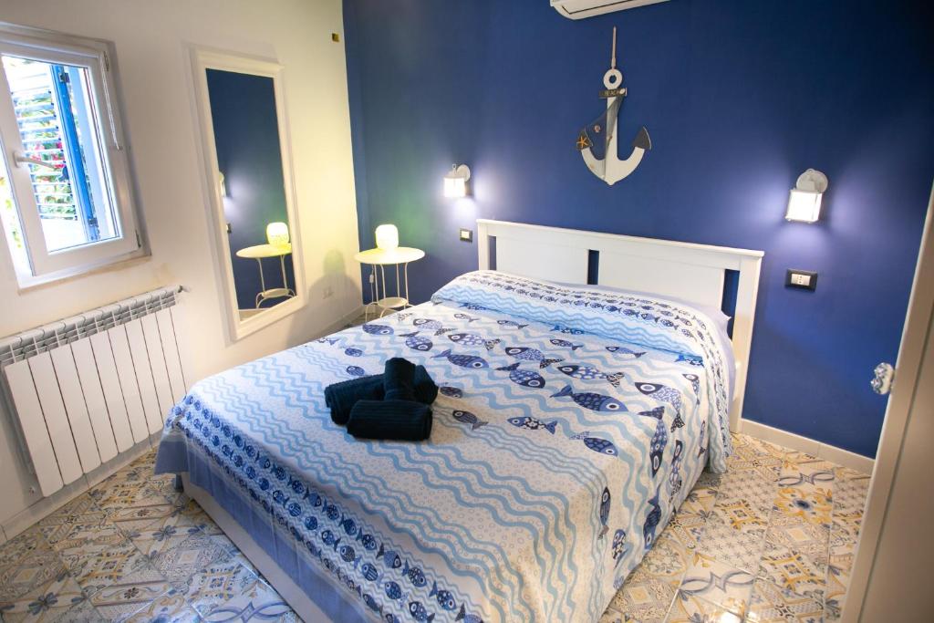 1 dormitorio con 1 cama con pared azul en DilettaAnna Luxury apartment en Tropea