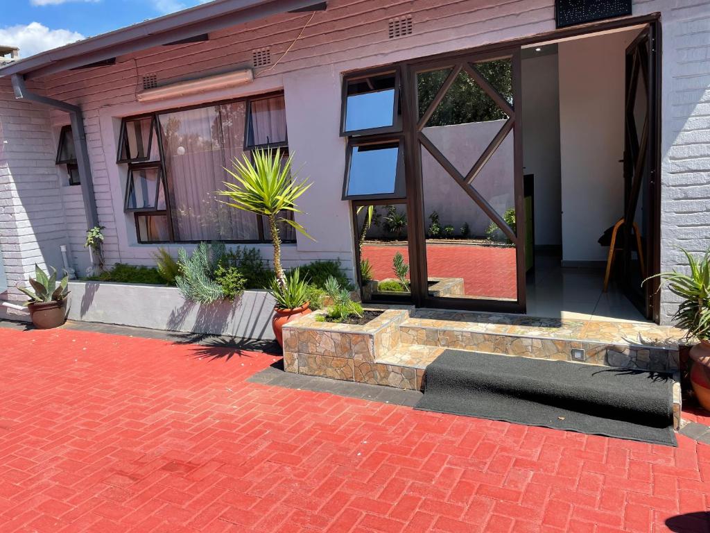 a house with a brick walkway in front of a door at Martyrs Guest House in Vanderbijlpark