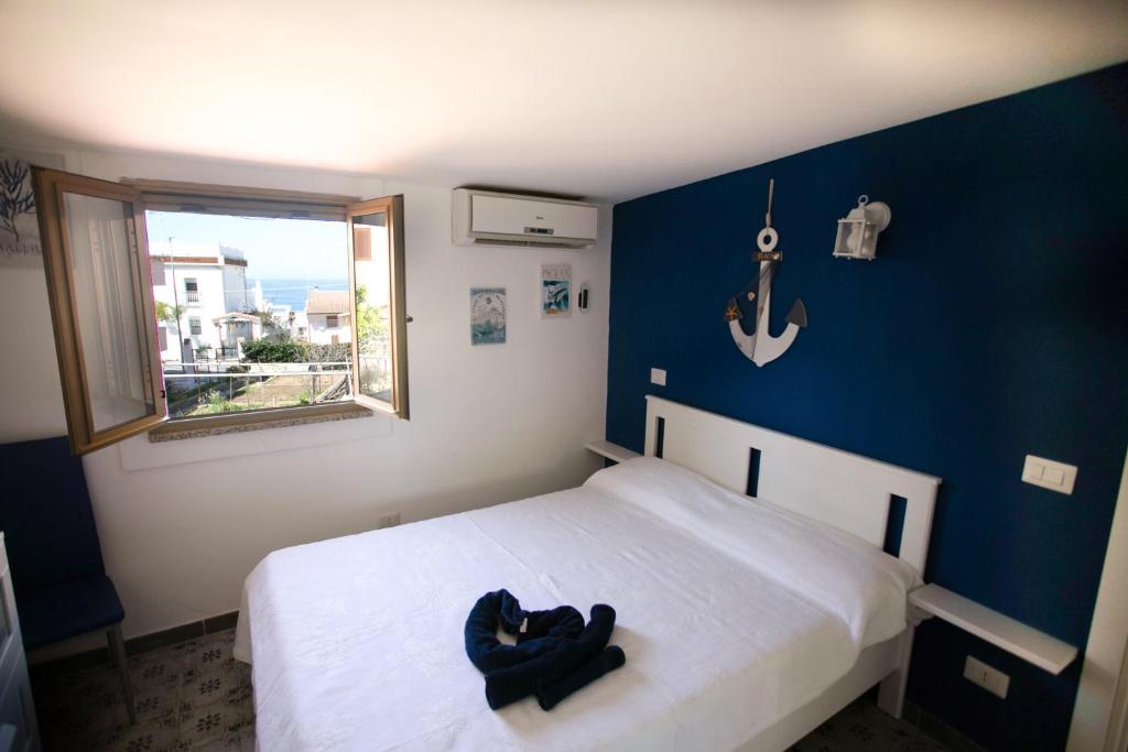 a bedroom with a white bed and a blue wall at DilettaAnna sea view appartment in Tropea