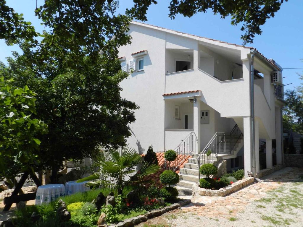 a white house with stairs and plants at Two-Bedroom Apartment in Malinska I in Sveti Vid-Miholjice