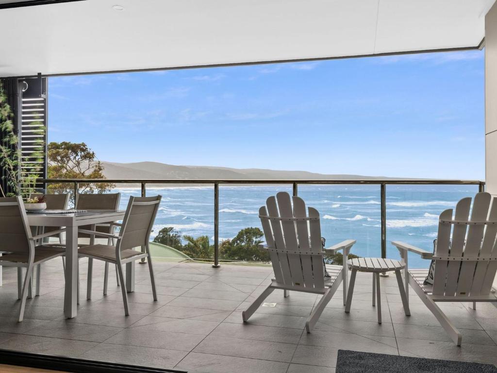 a table and chairs on a balcony with a view at Oceania 3 in Lorne