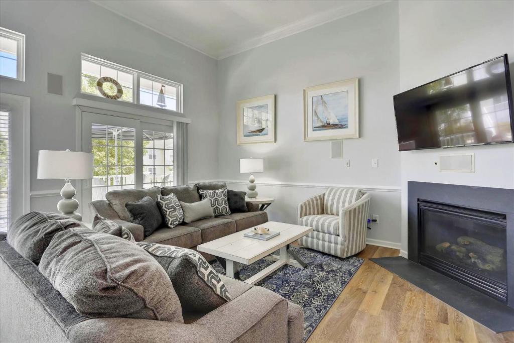 Ocean ViewにあるBayside Bethany Lakes - 38337 N Mill Ln 118のソファと暖炉のあるリビングルーム