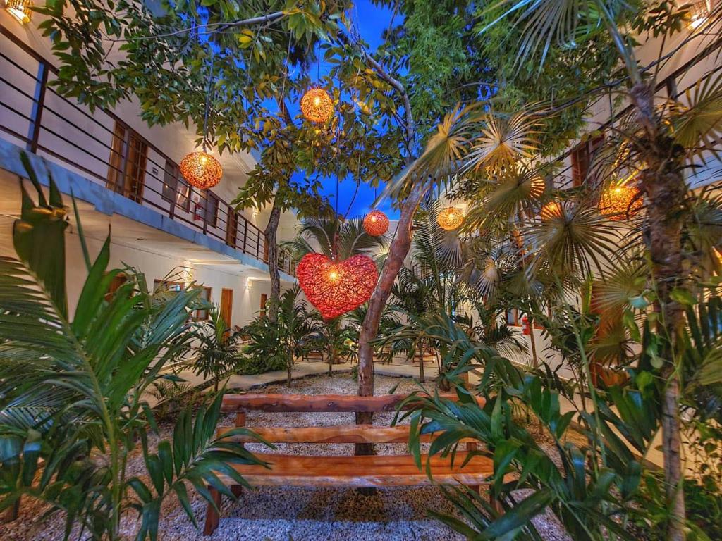 a garden with a heart hanging from a building at Los Arcos Hotel - TULUM in Tulum