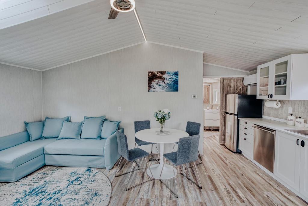 uma sala de estar com um sofá azul e uma mesa em Modern & Cozy stand-alone apartment - perfect stay em Painted Post