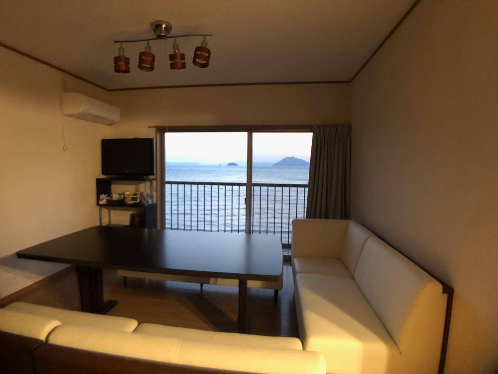 uma sala de estar com um sofá e uma mesa com vista em Villa Chillon - Vacation STAY 97710 em Sakate