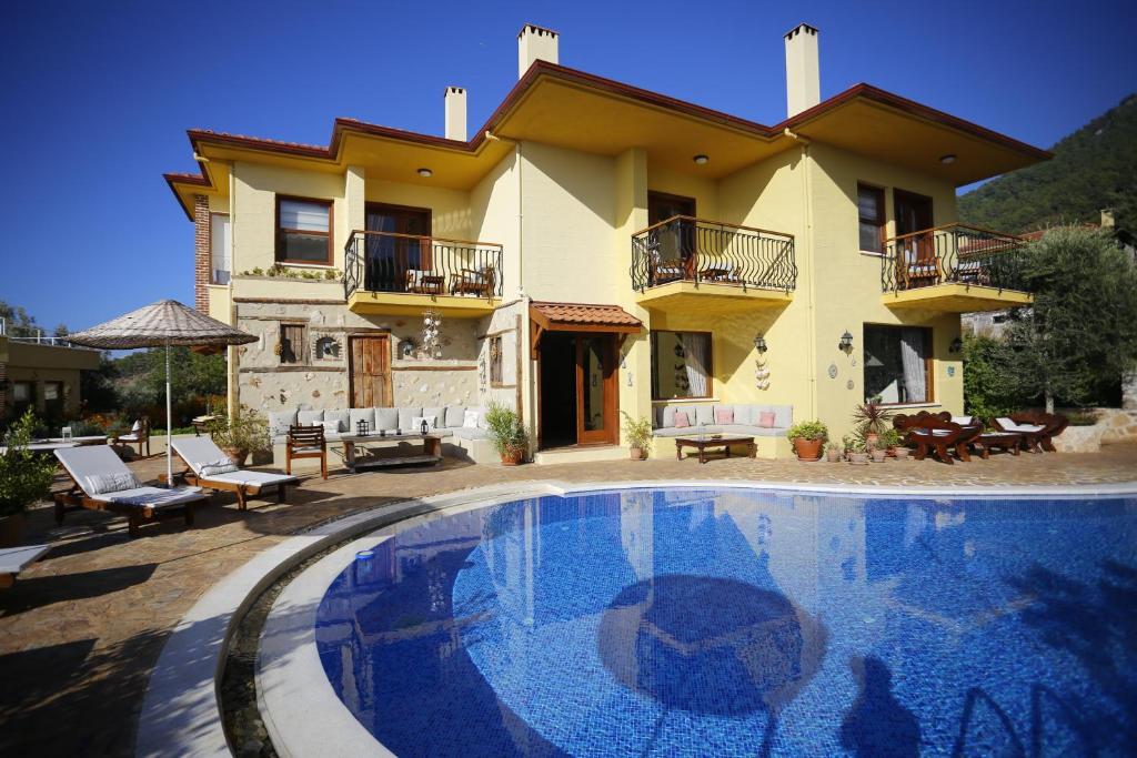 a villa with a swimming pool in front of a house at Exclusive Boutique Hotel in Kızılcakaya