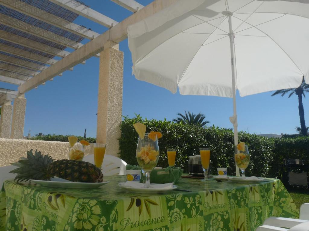una mesa con piña y vasos de zumo de naranja en Casa Mar Y Luz : the best location in the naturist zone of Vera Playa!, en Vera