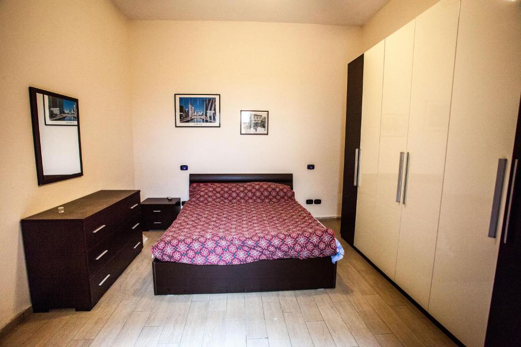 a bedroom with a bed and a dresser at Apartment Eutime- in Locri