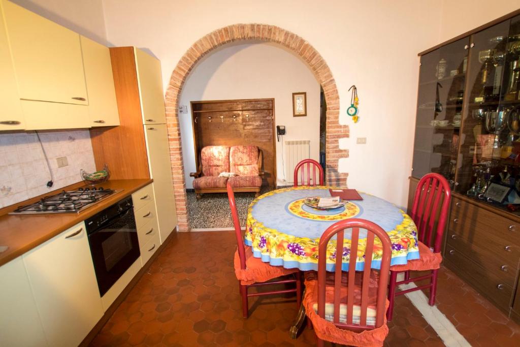 a kitchen with a table and chairs and a kitchen with a table and a room at Rustic Tuscan Apartment in Massa Marittima