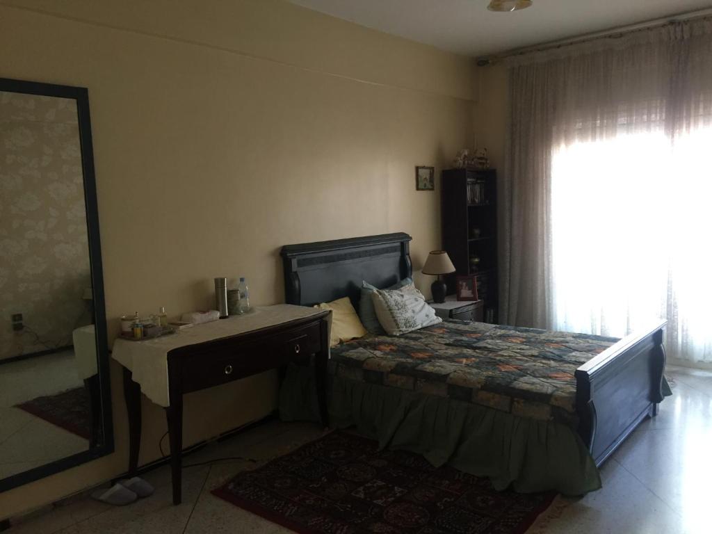 1 dormitorio con cama, escritorio y espejo en Property located in a quiet area near the train station, en Casablanca