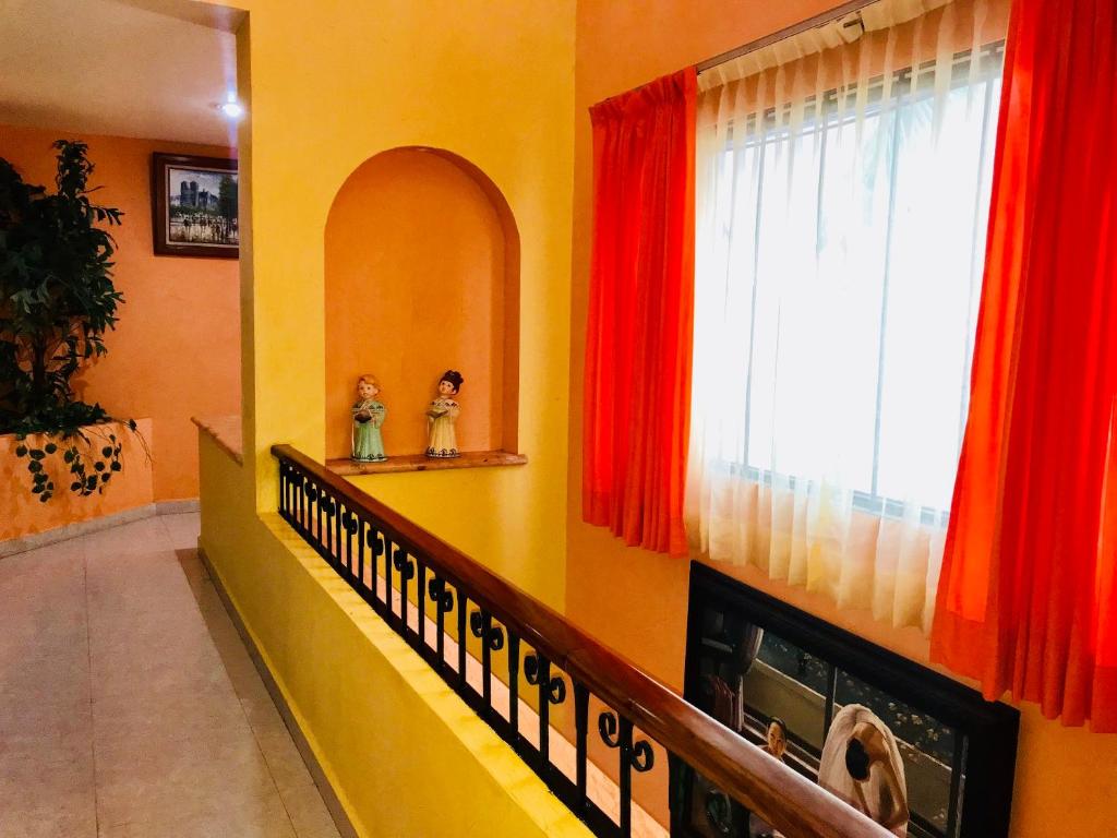a living room with a window with red curtains at Sunset Double Room in Stunning Villa Playacar Ii in Playa del Carmen