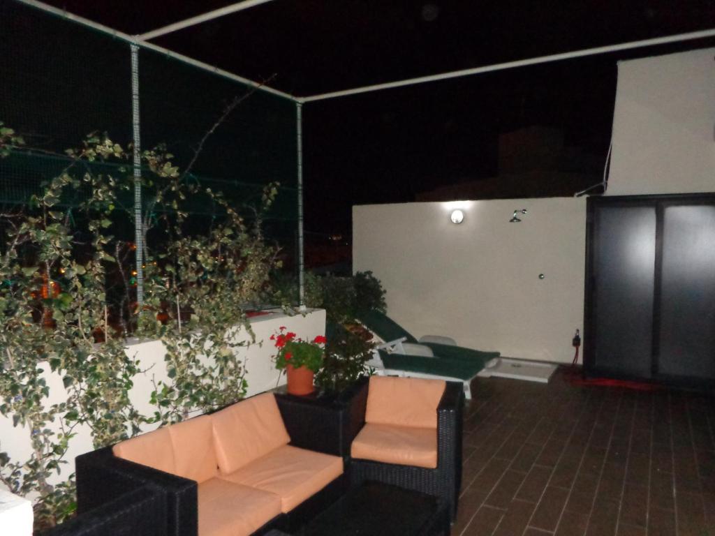 a patio with a couch and plants on the wall at Lovely Penthouse with private sun terrace between Valletta and Sliema in Taʼ Xbiex