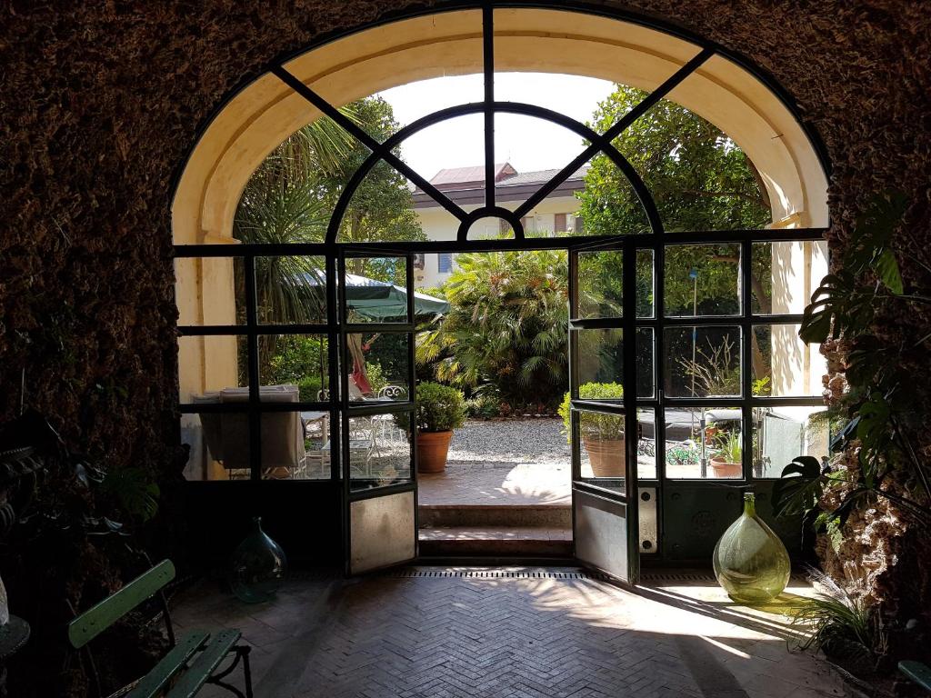 uma porta aberta para um jardim com um pátio em Dimora Aganoor: the guesthouse - relais & gourmet - a few steps from the divine em Cava deʼ Tirreni