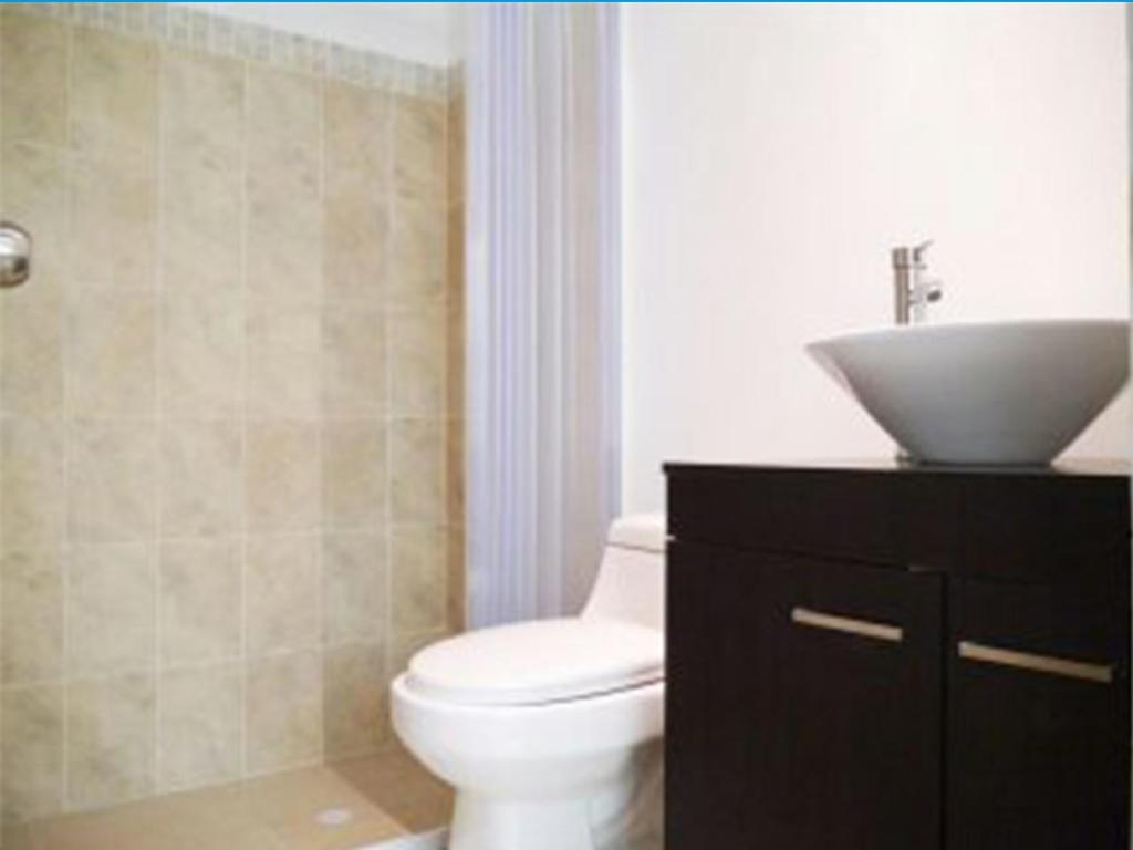 a bathroom with a white toilet and a sink at Holiday home in Gaira in Santa Marta