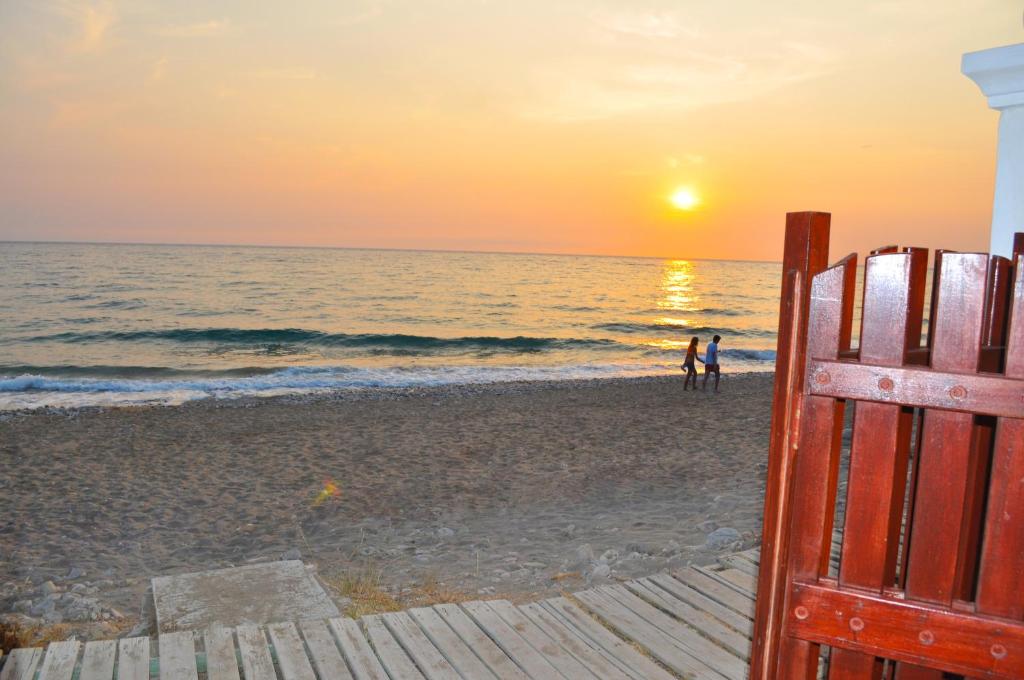 a view of the beach at sunset at Beachfront holiday house Eftichia in Agios Gordios