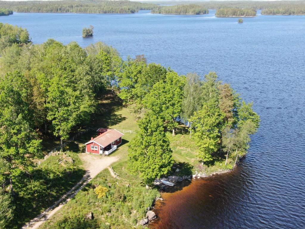 uma ilha no meio de um lago com uma casa em Joarsbo, Stuga 1, Sjölyckan em Kalv