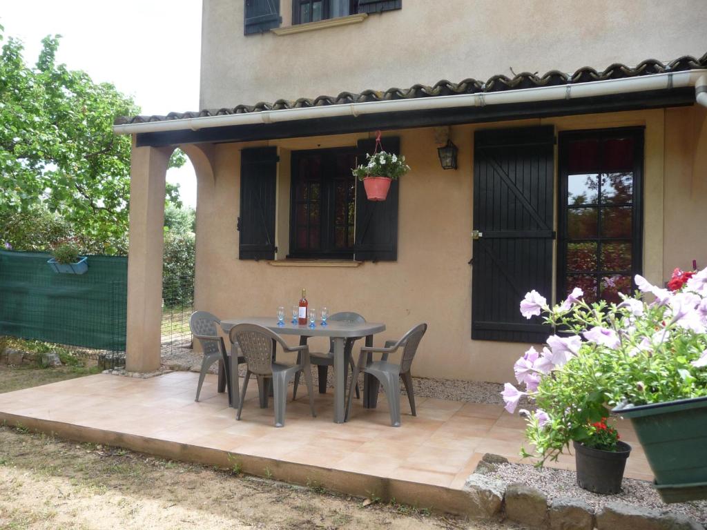 a patio with a table and chairs in front of a house at furniture tourism ground floor in Vidauban