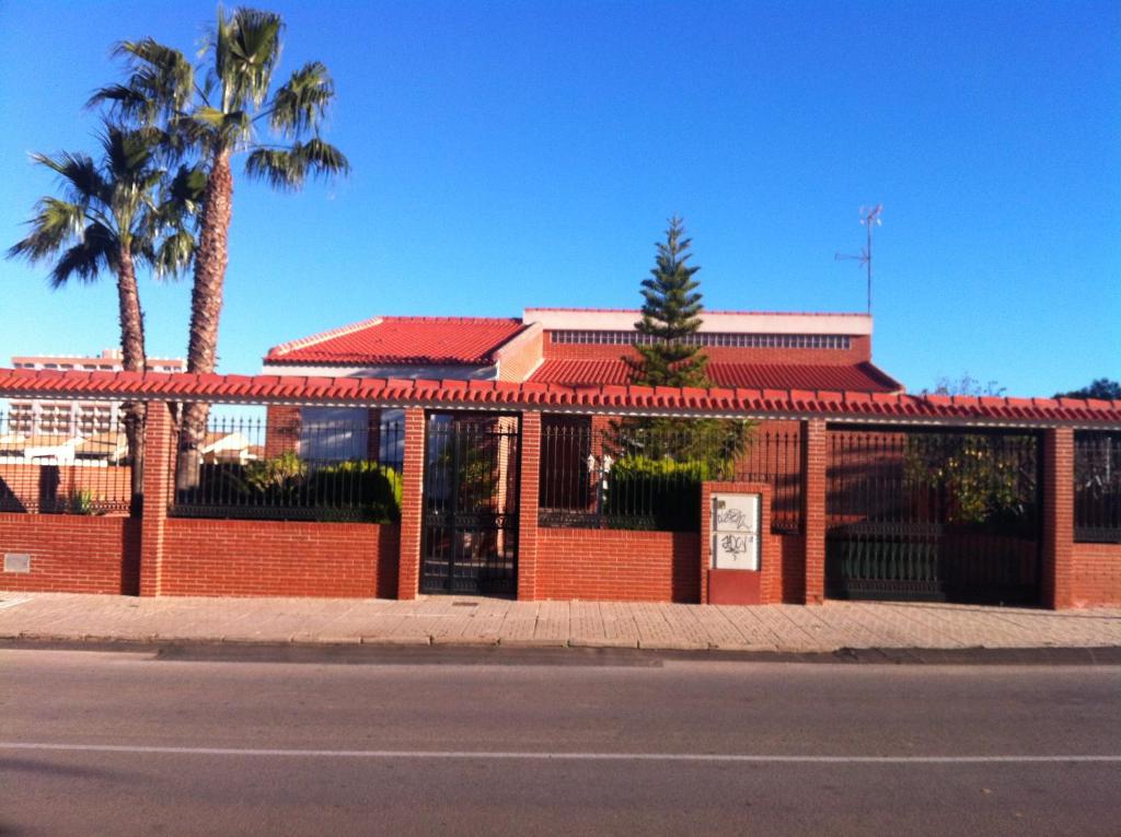 un edificio de ladrillo rojo con palmeras y una calle en Luxury villa in Playa Honda, en Cartagena