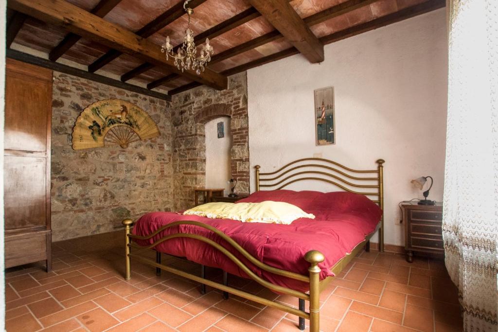 a bedroom with a bed with a red blanket at Rustic Tuscan style apartment in Massa Marittima