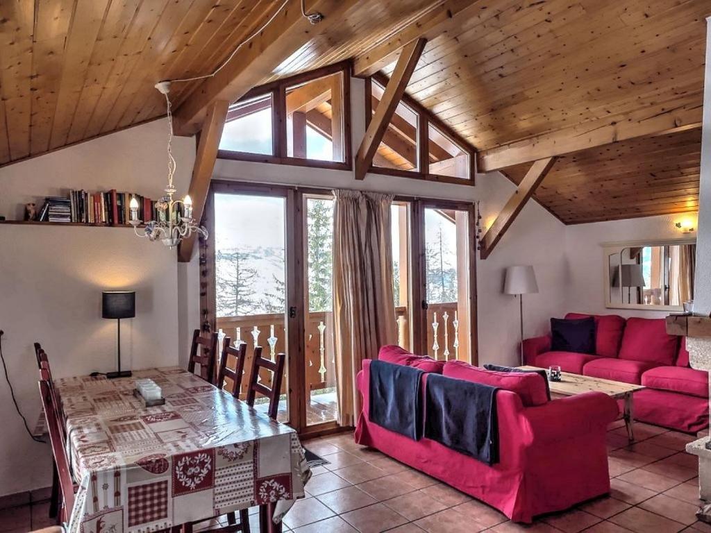 een woonkamer met een rode bank en een tafel bij Chalet Chamois in Landry