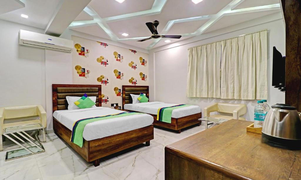 a bedroom with two beds and a television in it at Treebo Trend Orion Sapphire in Ballygunge