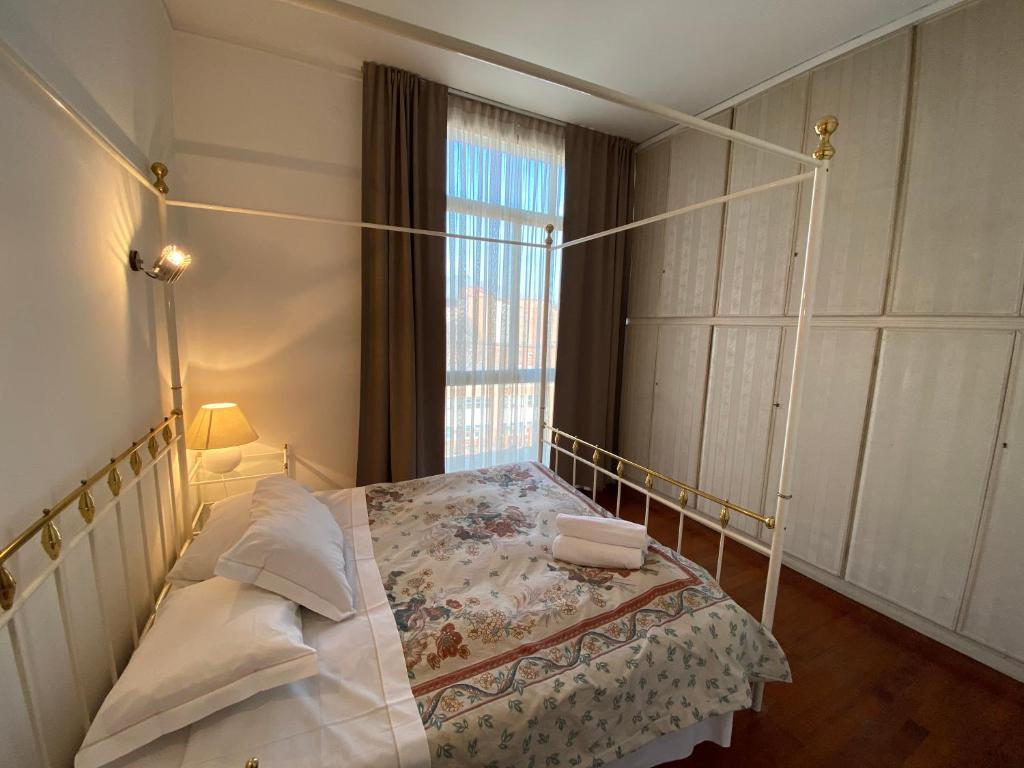a bedroom with a canopy bed and a window at Appartamenti Leonardo in Brescia