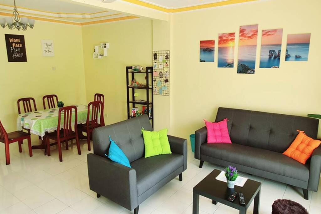 a living room with two couches and a table at Colourful homestay - (near jeti sky mirror) in Kuala Selangor