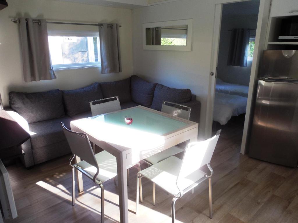 a living room with a couch and a table and chairs at Rives Nature in La Gacilly