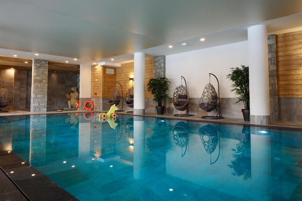 a large swimming pool in a hotel with plants on it at CGH Résidence Boutique Le Lodge des Neiges in Tignes