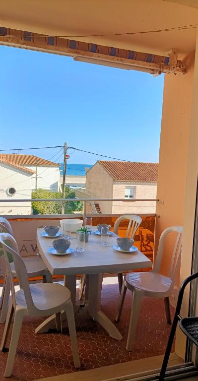 une table et des chaises sur un balcon avec vue sur l'océan dans l'établissement Appartement T2 - 2 a 4 Personnes - Vue sur Mer - 4CAPE2N10, à Narbonne-Plage
