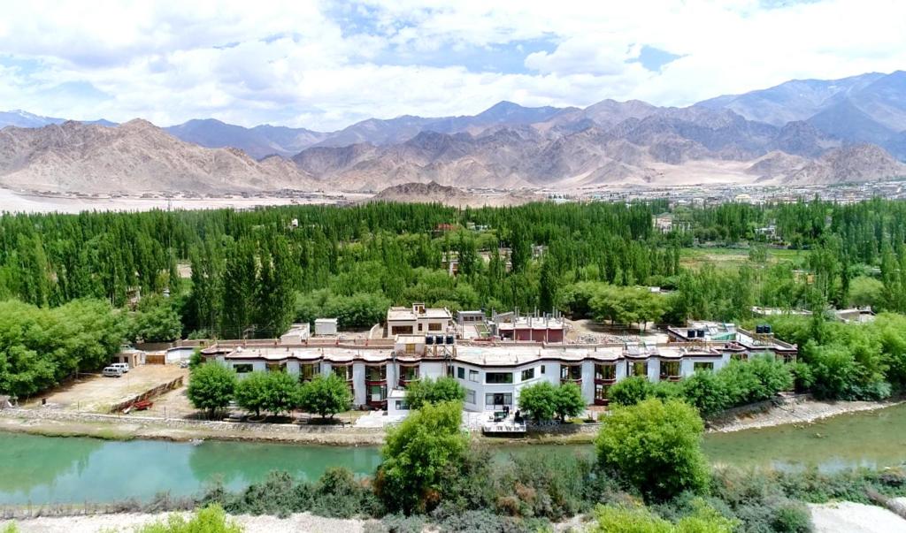 an aerial view of a resort with a river and mountains at The Nature Residency - A Riverside Resort in Leh in Leh