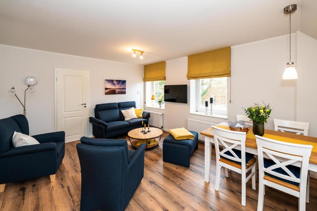 Una sala de estar con una mesa y sillas y un sofá. en Bauernhaus-Wohnung-2, en Bojendorf