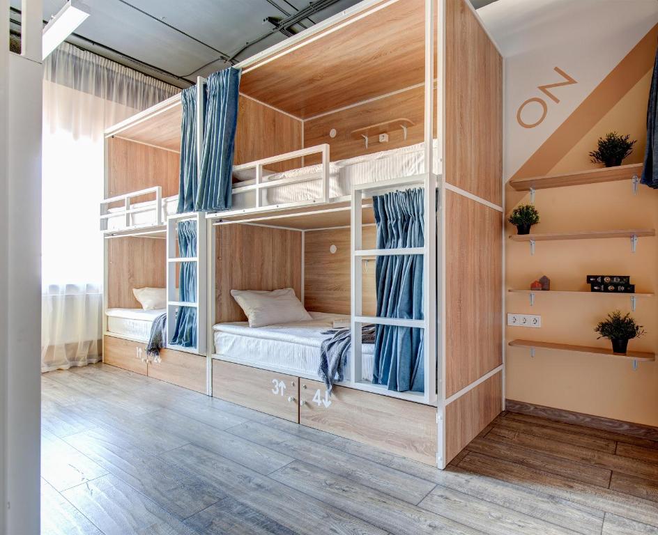 a room with bunk beds with blue curtains at Roomy Hostel in Yekaterinburg
