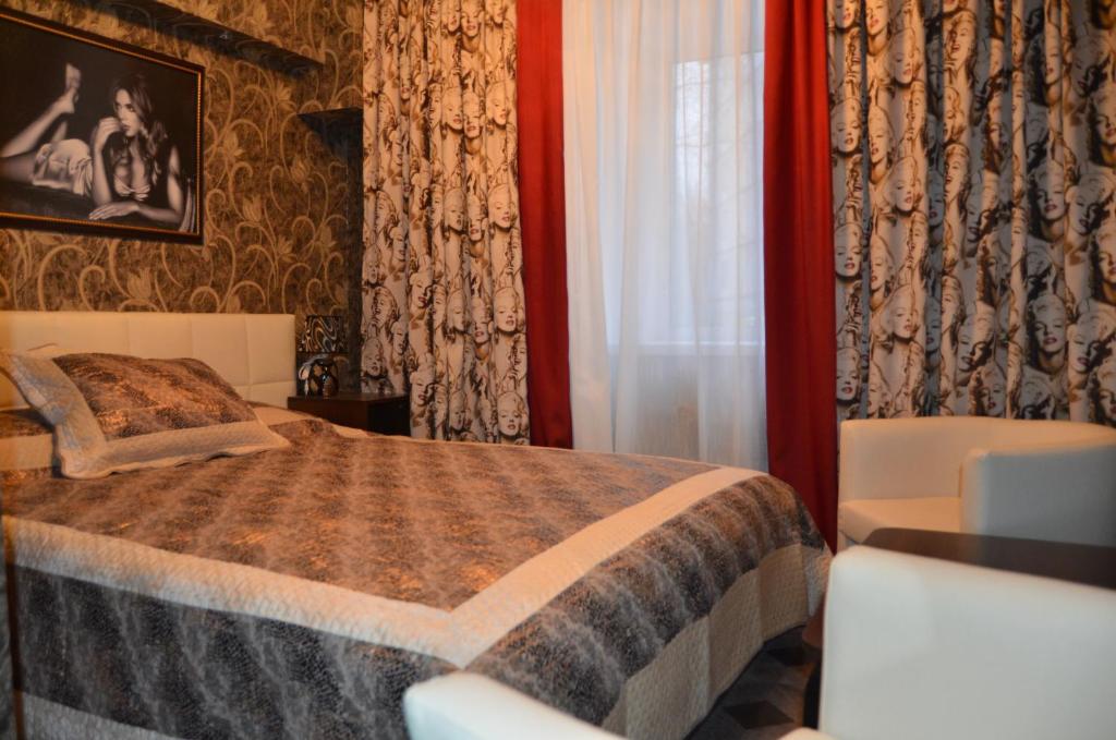 a bedroom with a bed and a window and curtains at Vystavka Hotel in Moscow