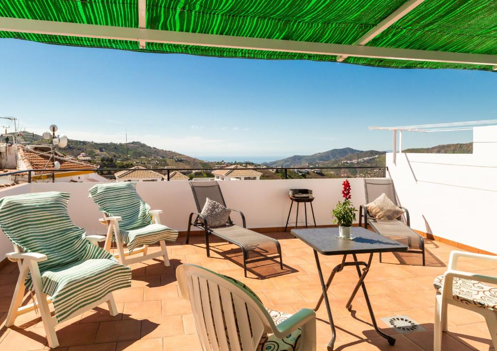 un patio con sillas y una mesa en el techo en Apartamento Rural Antares, en Cómpeta