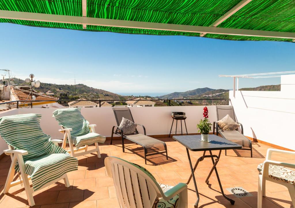 a patio with chairs and a table on a roof at Vivienda Rural Antares in Cómpeta